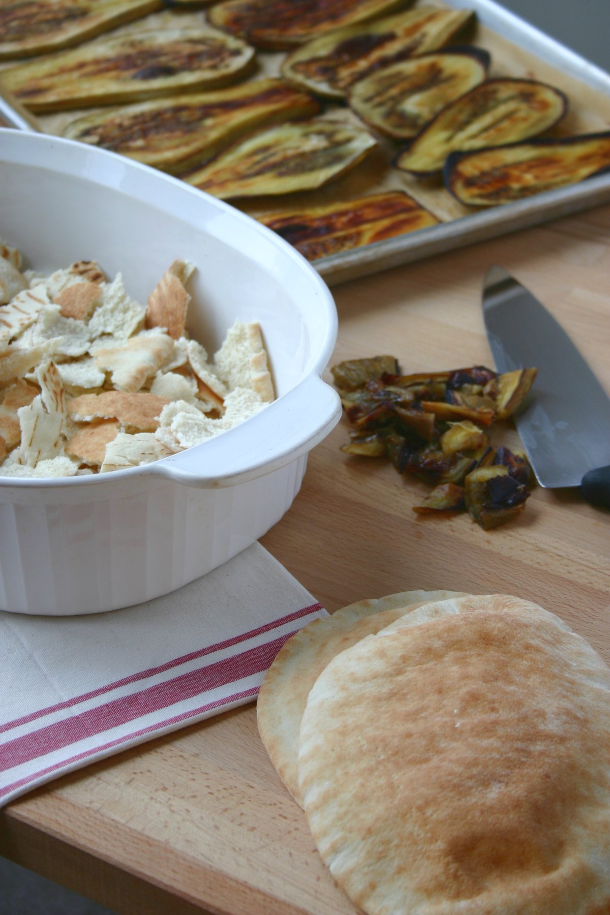 This recipe for Eggplant Fatteh, a Middle Eastern casserole dish, features toasted pita bread, a spiced tomato sauce, and a lemony tahini topping.