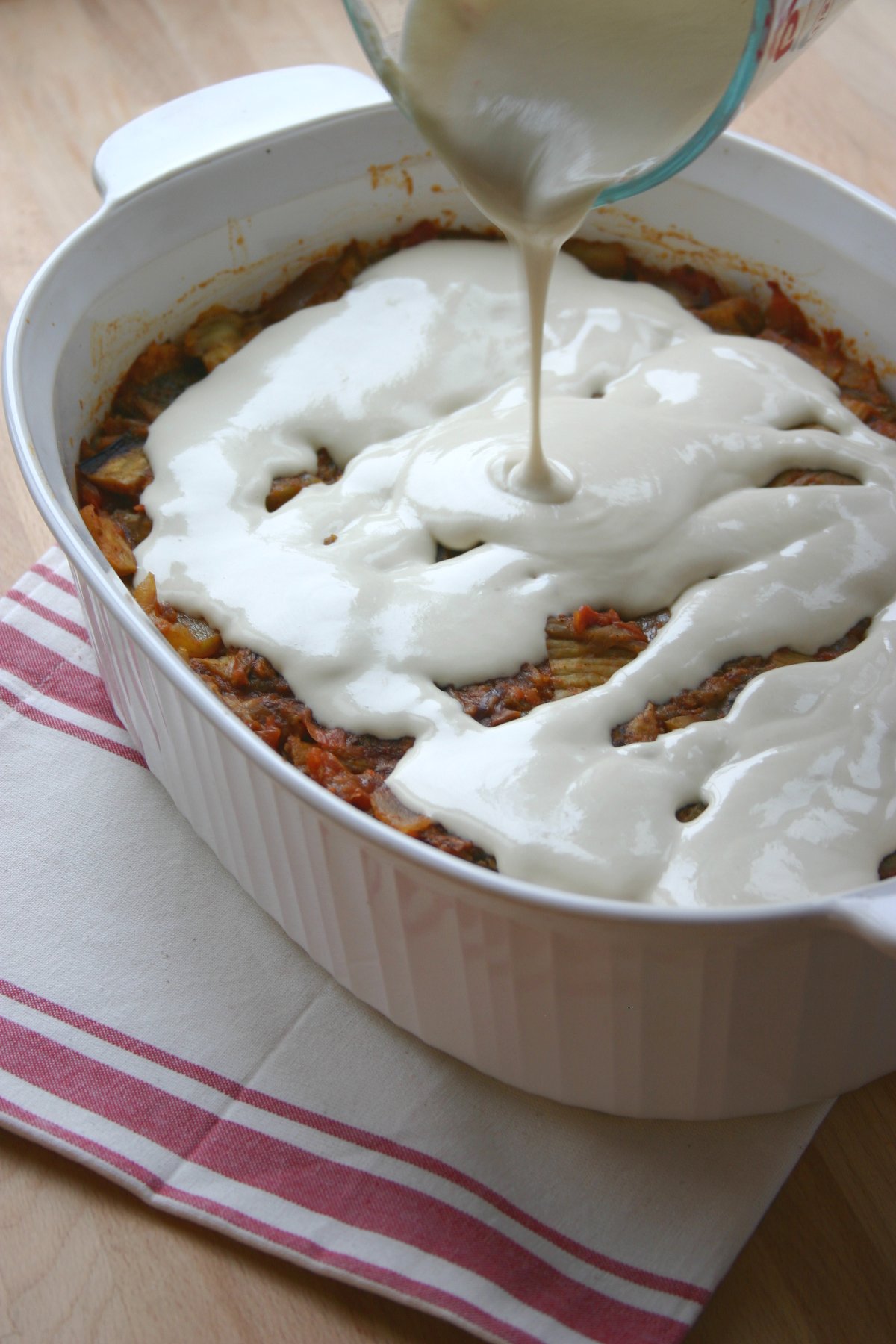 This recipe for Eggplant Fatteh, a Middle Eastern casserole dish, features toasted pita bread, a spiced tomato sauce, and a lemony tahini topping.