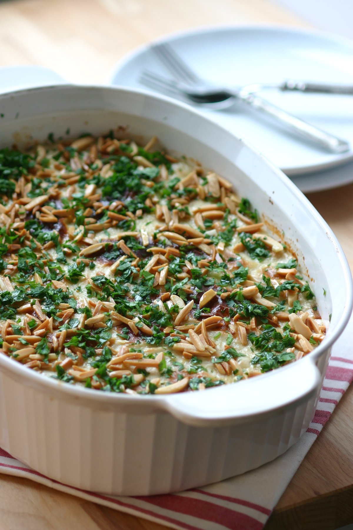 This recipe for Eggplant Fatteh, a Middle Eastern casserole dish, features toasted pita bread, a spiced tomato sauce, and a lemony tahini topping.