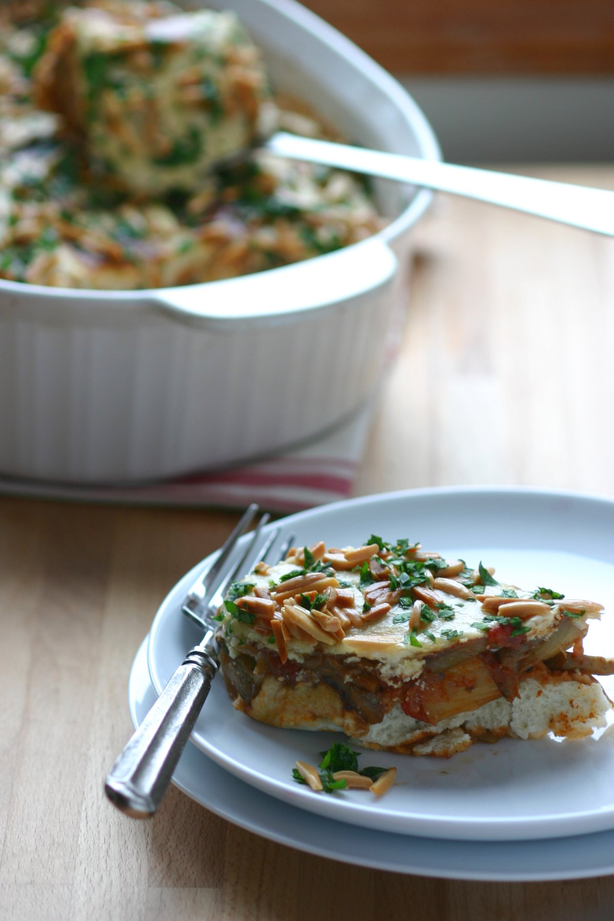 This recipe for Eggplant Fatteh, a Middle Eastern casserole dish, features toasted pita bread, a spiced tomato sauce, and a lemony tahini topping.