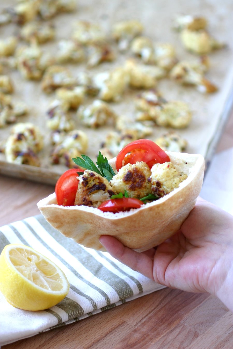 An easy recipe for Roasted Spiced Cauliflower with cumin, pepper, and mint and finished with a squeeze of lemon. Use as a side or stuff into sandwiches.