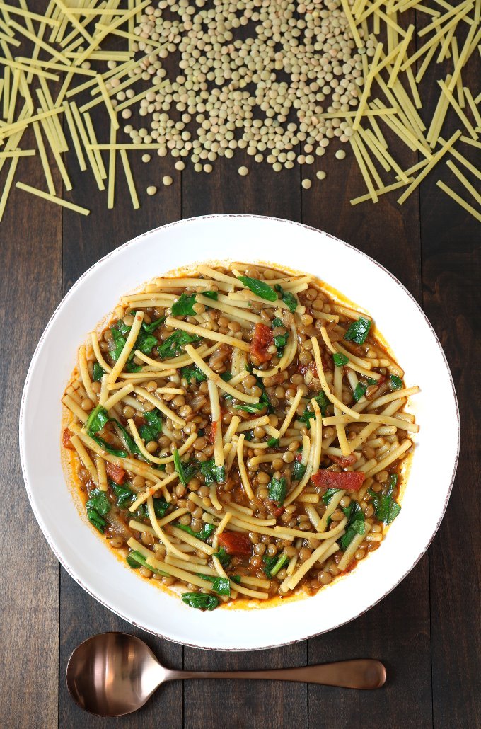 Lentils, noodles, carmelized onions, tomatoes, and a spiced broth come together to make this filling Lentil and Spinach Rashteh.